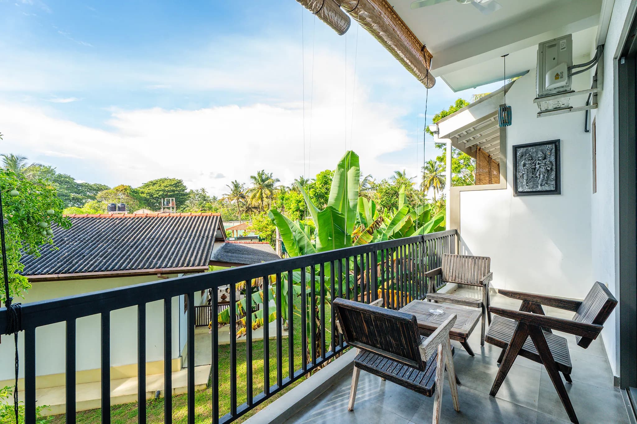 Balcony view over rooftops and banana trees