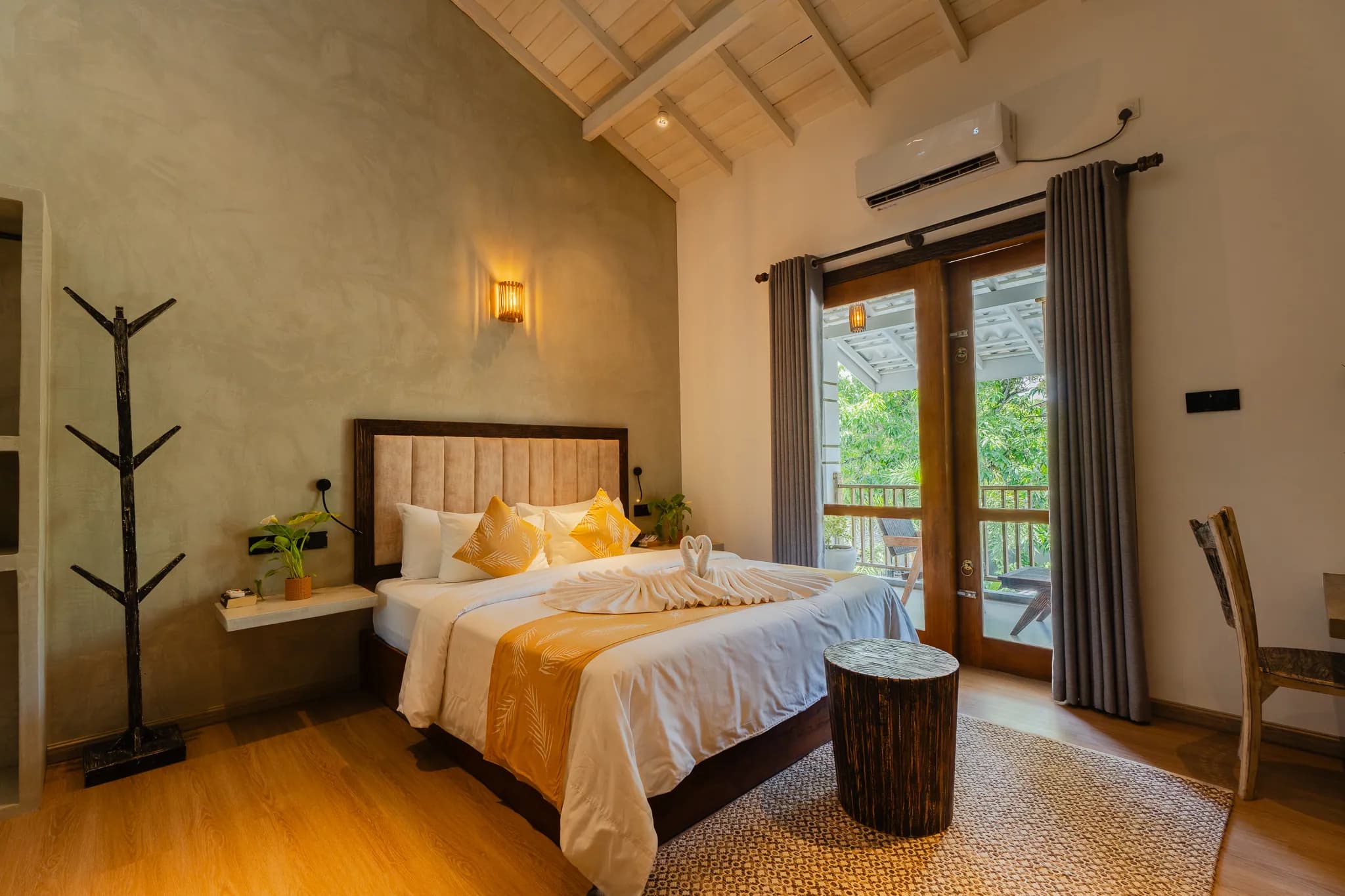 King bed with ochre throw and open doors to a balcony