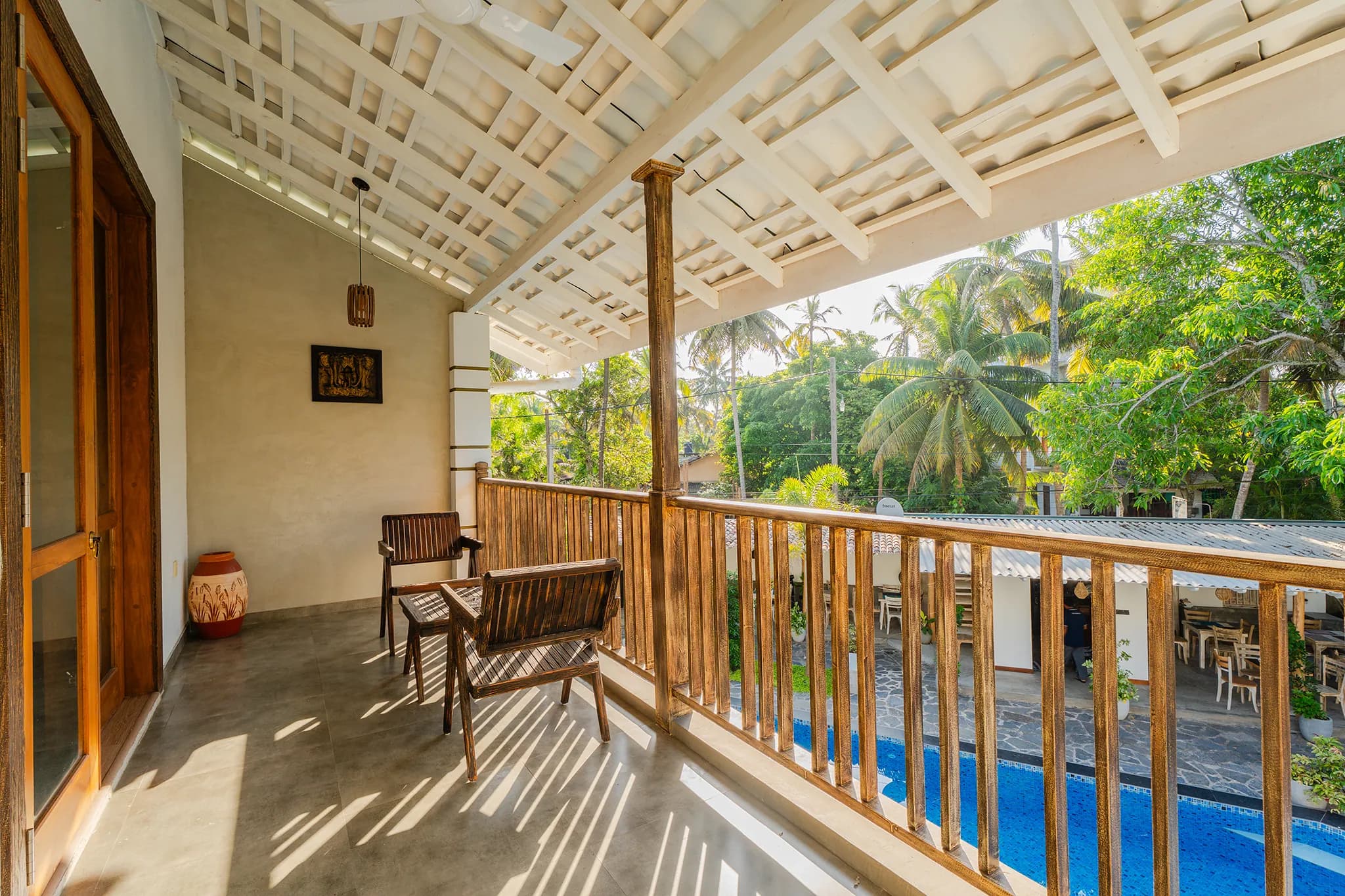 Covered balcony with chairs looking down onto the pool