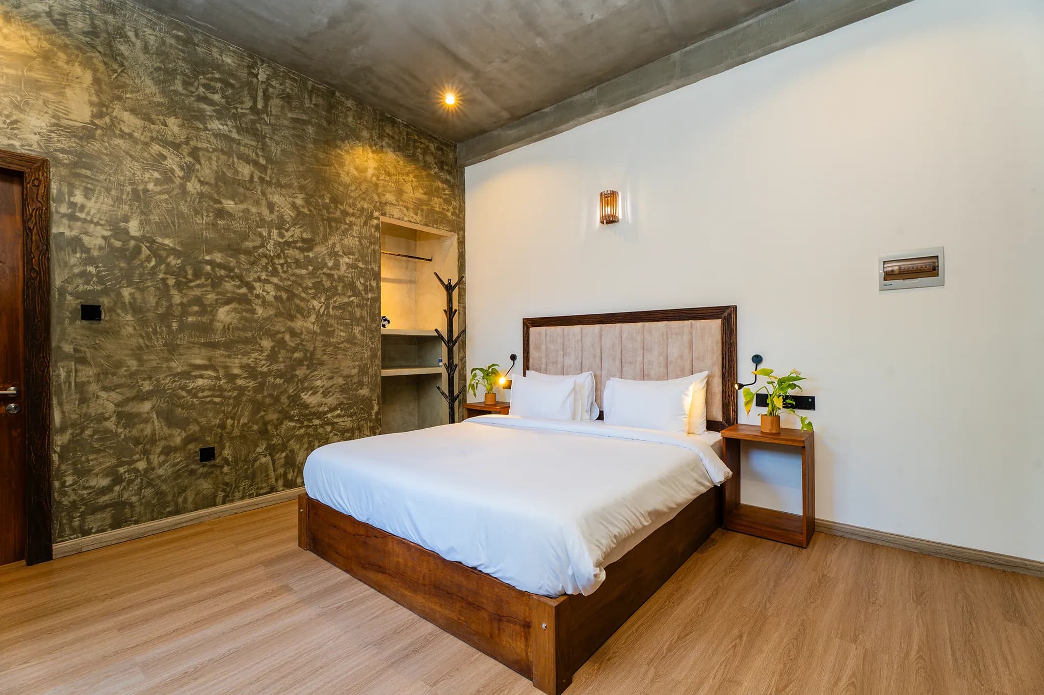 King bed beneath a vaulted ceiling with a stone feature wall