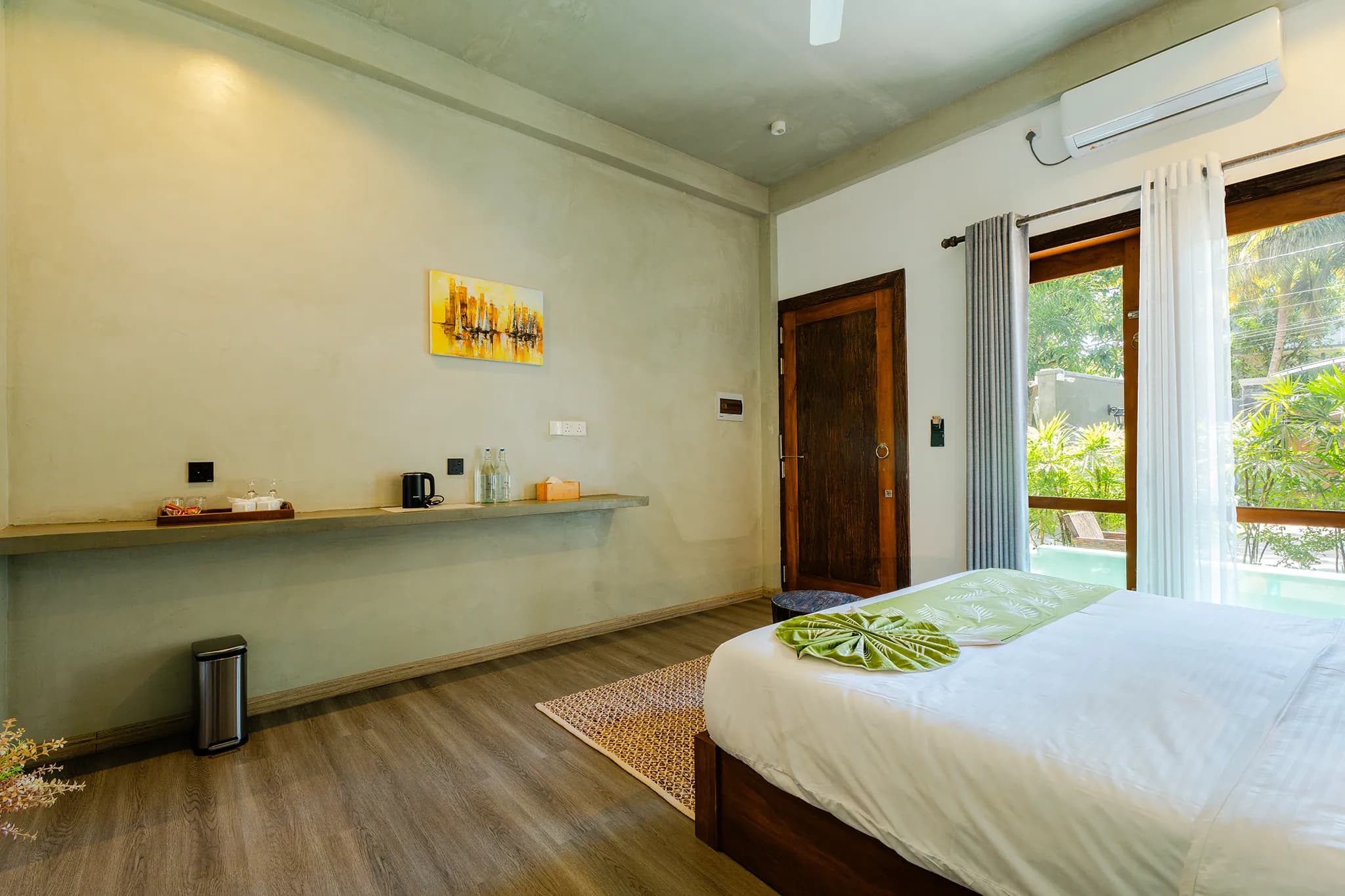 King bed with green cushions and doors to a garden patio