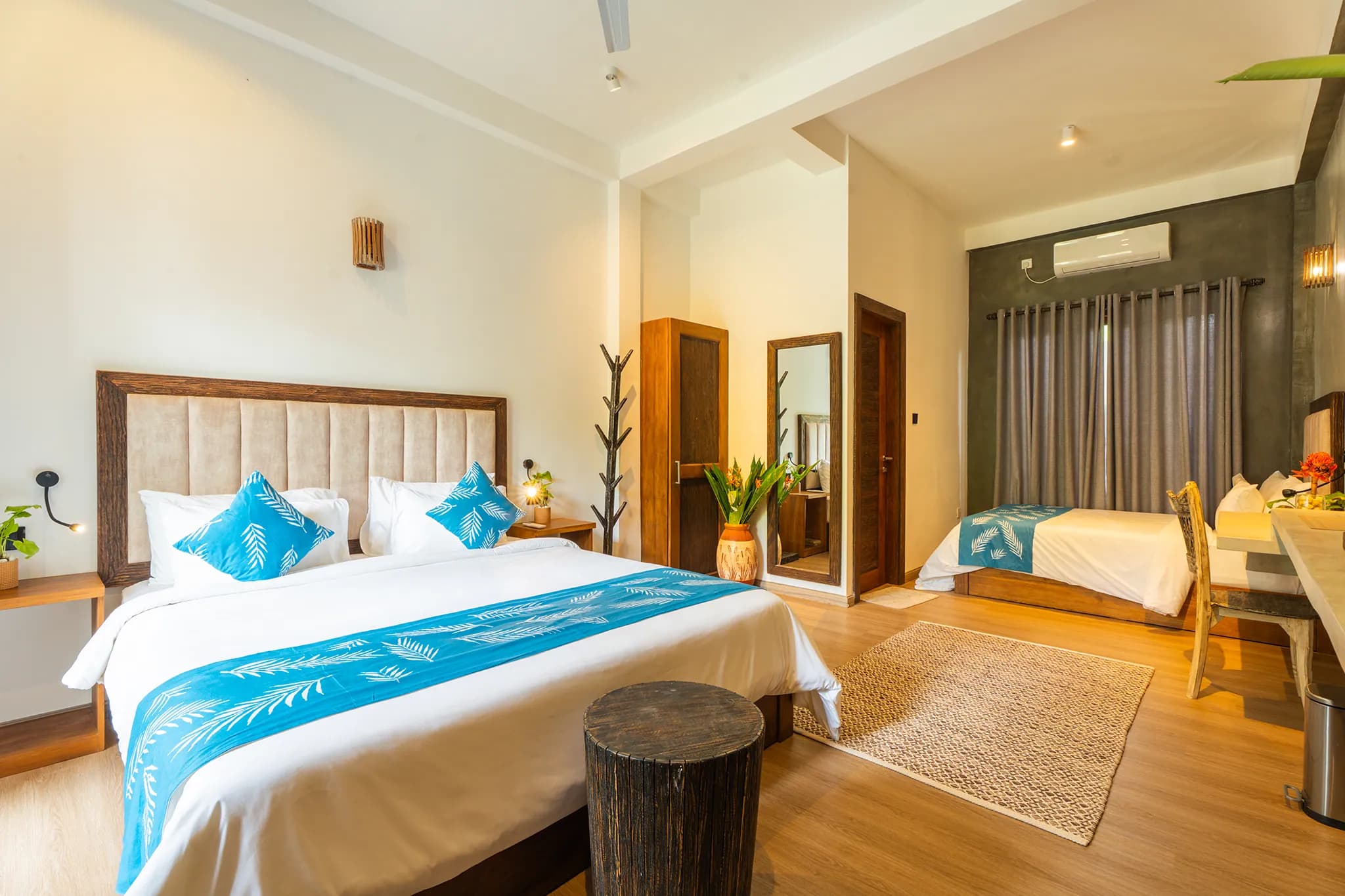 King bed with blue palm-print runner beside a window onto the garden