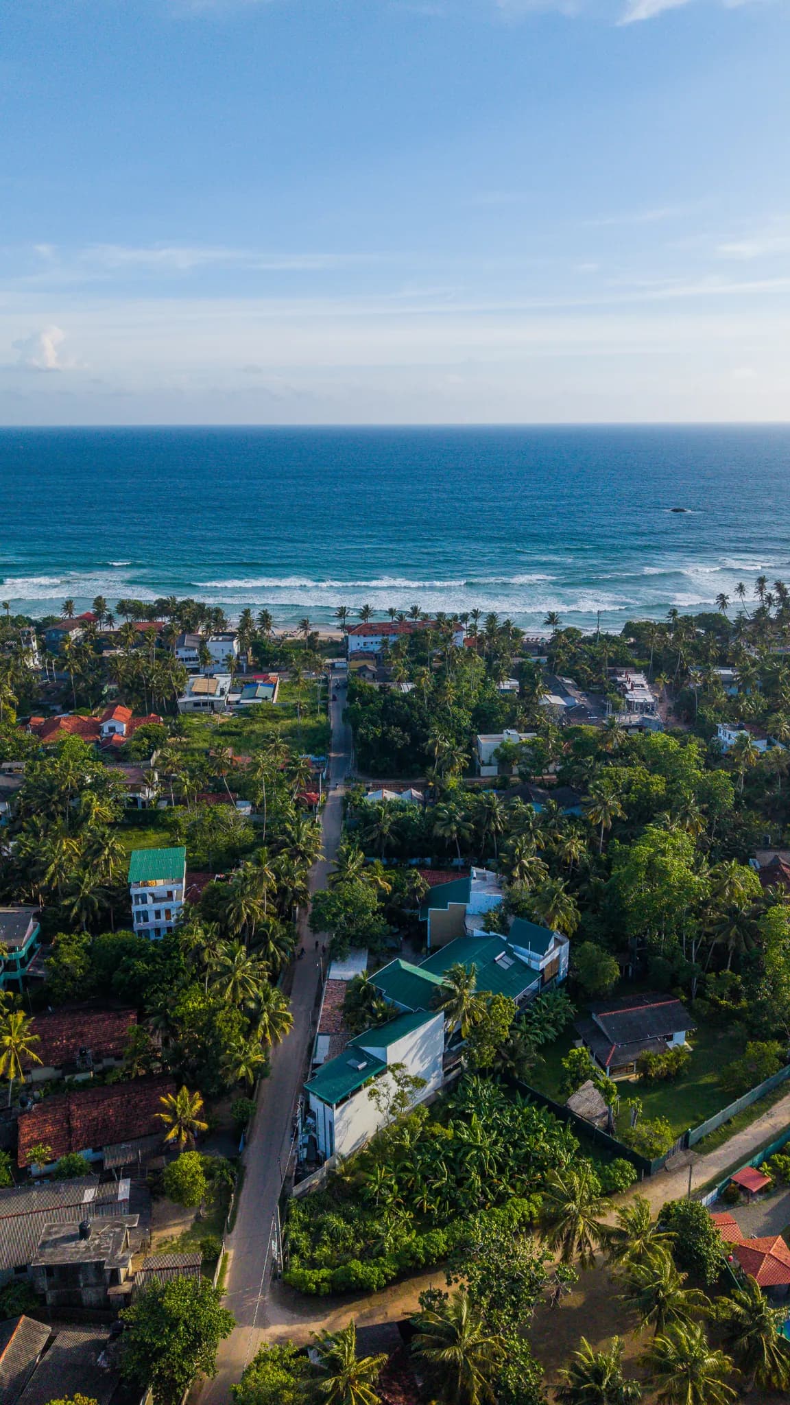 Aerial view of the Ahangama coastline with waves breaking along the reef