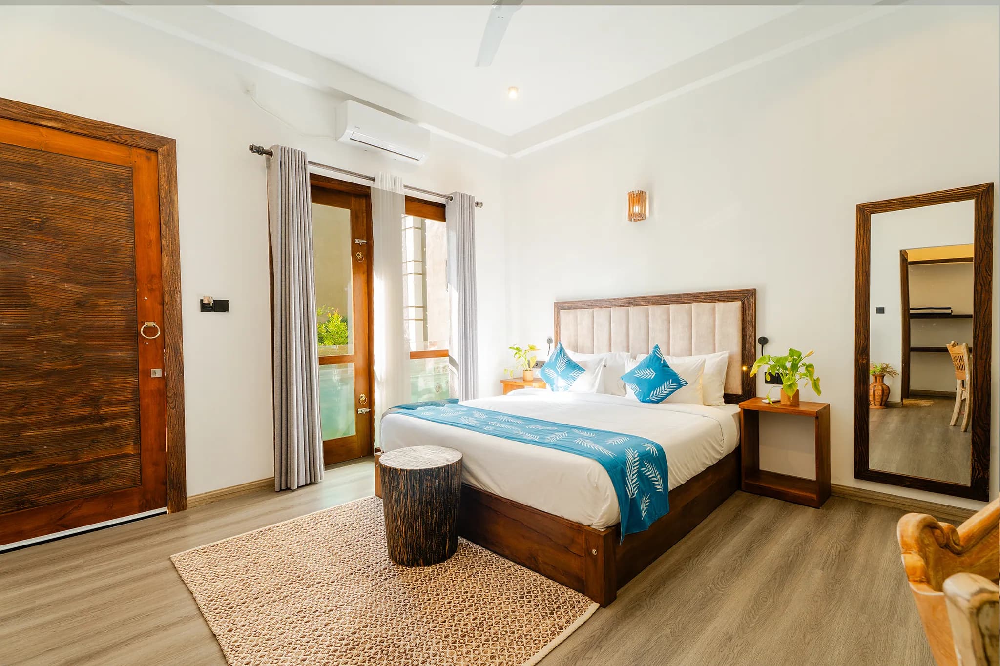 King bed with blue runner and doors to a private patio