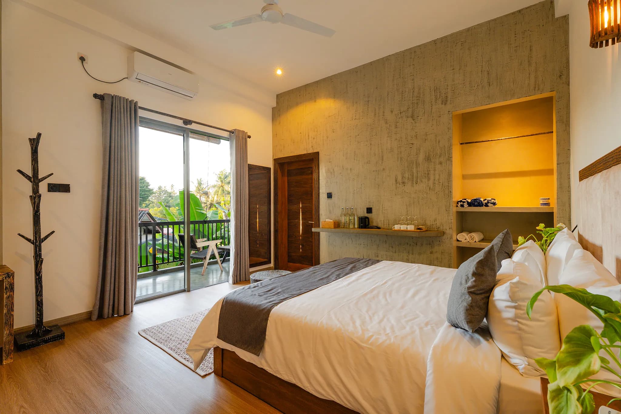 King bed with grey throw and doors to a balcony